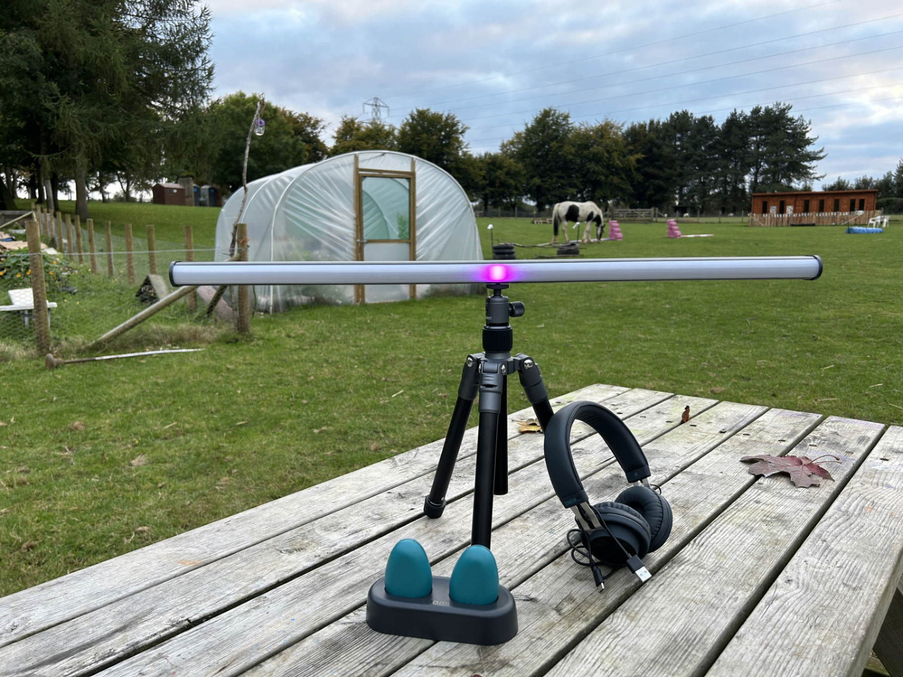 Therapy equipment and headphones on a wooden picnic table at the farm